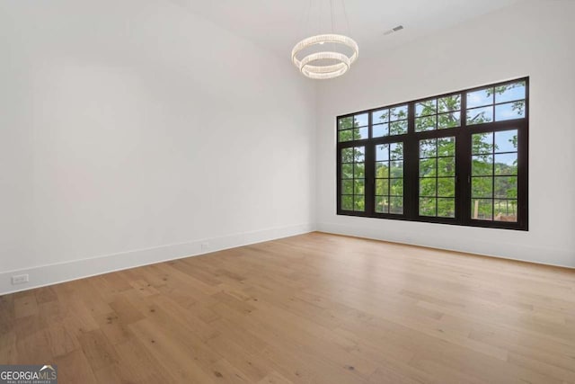 245 Traditions Dr, Alpharetta, GA 30004 - unfurnished room featuring a chandelier and light wood-style floors
