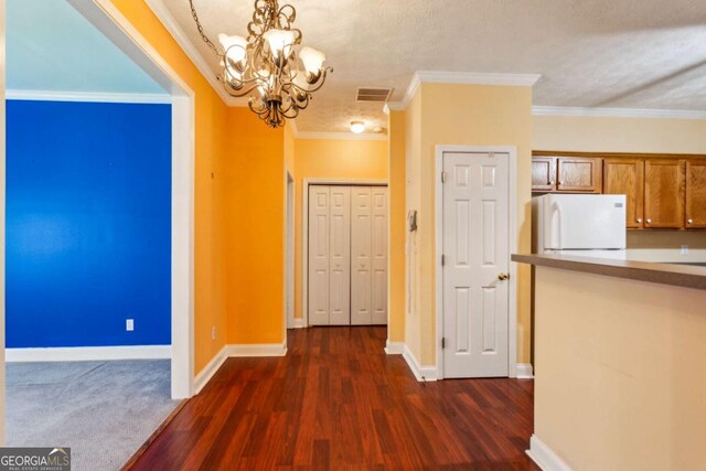 99 Rainwater Ln, Dallas, GA 30157 - unfurnished dining area with a chandelier, dark wood-type flooring, crown molding, and a textured ceiling