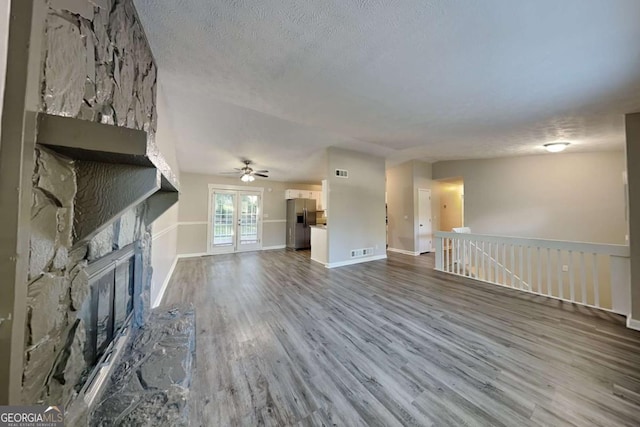 2478 Wood Meadows Dr SW, Marietta, GA 30064 - unfurnished living room featuring a fireplace, wood finished floors, a ceiling fan, and a textured ceiling