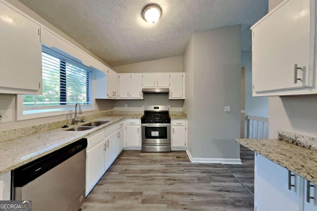 2478 Wood Meadows Dr SW, Marietta, GA 30064 - kitchen with stainless steel appliances, under cabinet range hood, a textured ceiling, white cabinetry, and vaulted ceiling