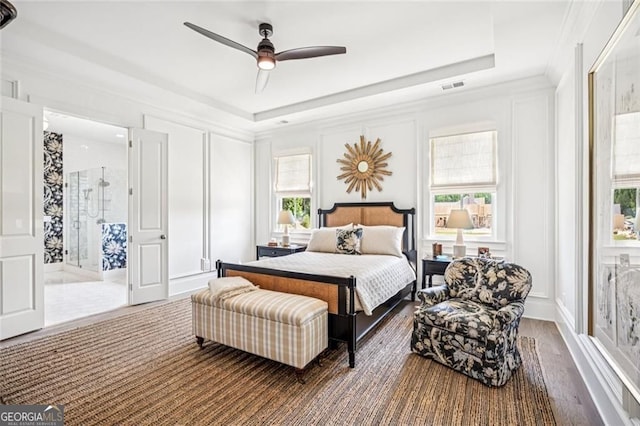 1057 Crossroads Trl, Milton, GA 30004 - bedroom featuring a decorative wall, a tray ceiling, wood finished floors, a ceiling fan, and ensuite bath