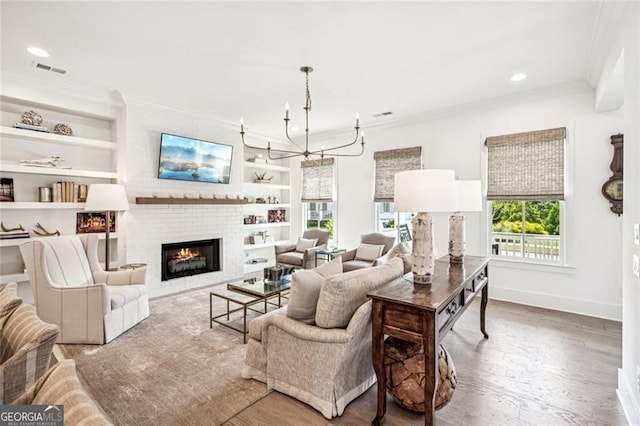 1057 Crossroads Trl, Milton, GA 30004 - living area with ornamental molding, built in features, healthy amount of natural light, a brick fireplace, and wood finished floors