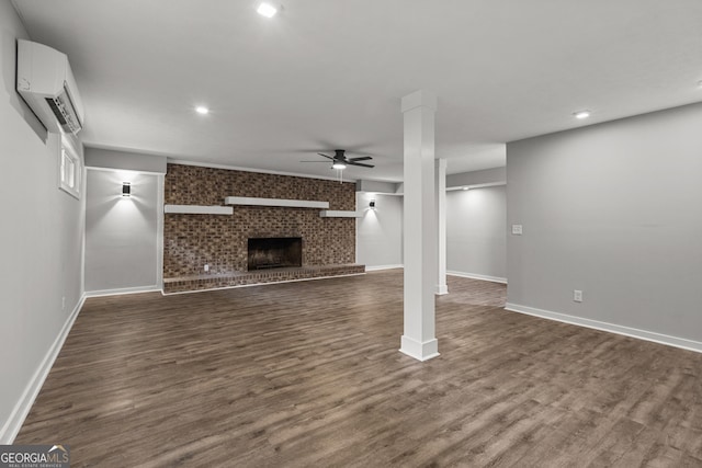 1000 Jones Rd, Cataula, GA 31804 - unfurnished living room featuring a wall mounted AC, ceiling fan, dark wood-style floors, a large fireplace, and baseboards