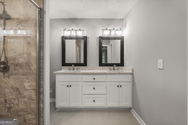 1000 Jones Rd, Cataula, GA 31804 - bathroom with a stall shower, double vanity, a textured ceiling, and baseboards