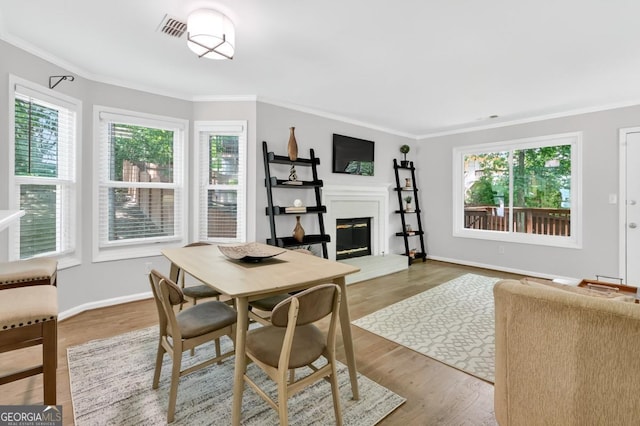 5037 Laurel Springs Way SE, Smyrna, GA 30082 - dining space featuring a glass covered fireplace, crown molding, and wood finished floors