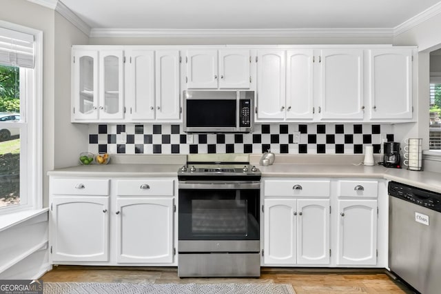 5037 Laurel Springs Way SE, Smyrna, GA 30082 - kitchen with appliances with stainless steel finishes, white cabinets, light countertops, backsplash, and ornamental molding