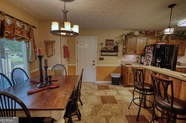 55 Ashton Pl, Covington, GA 30016 - dining room with a chandelier, stone finish flooring, a textured ceiling, and baseboards