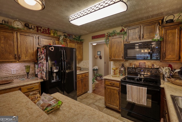 55 Ashton Pl, Covington, GA 30016 - kitchen featuring black appliances, light countertops, tasteful backsplash, brown cabinets, and a textured ceiling