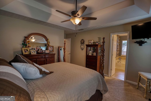 55 Ashton Pl, Covington, GA 30016 - bedroom featuring a tray ceiling, light colored carpet, baseboards, ensuite bath, and ceiling fan