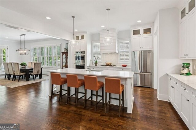 5971 Brundage Ln, Norcross, GA 30071 - kitchen with stainless steel appliances, light countertops, a breakfast bar, a center island with sink, and white cabinets