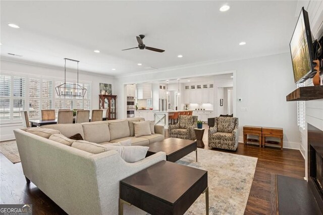 5971 Brundage Ln, Norcross, GA 30071 - living area featuring a fireplace with flush hearth, ceiling fan, ornamental molding, dark wood-type flooring, and recessed lighting