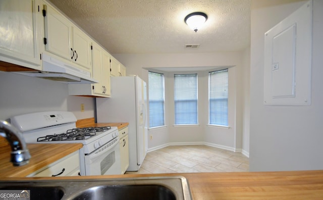 775 Heritage Valley Rd, Norcross, GA 30093 - kitchen with white appliances, under cabinet range hood, light tile patterned floors, white cabinets, and a textured ceiling