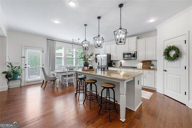 2680 Augeron Ct, Alpharetta, GA 30004 - kitchen with stainless steel appliances, a breakfast bar area, an island with sink, ornamental molding, and white cabinets