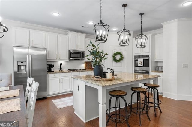 2680 Augeron Ct, Alpharetta, GA 30004 - kitchen with stainless steel appliances, a chandelier, dark wood-style floors, pendant lighting, and white cabinets