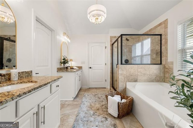 2680 Augeron Ct, Alpharetta, GA 30004 - bathroom featuring a chandelier, two vanities, a shower stall, vaulted ceiling, and a garden tub