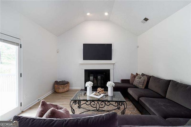 3185 Perch Dr SW, Marietta, GA 30008 - living area with vaulted ceiling, wood finished floors, baseboards, a glass covered fireplace, and recessed lighting