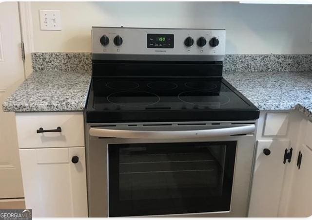 1271 Rigdon Rd, Columbus, GA 31906 - kitchen view of stainless steel electric range, light stone countertops, and white cabinets