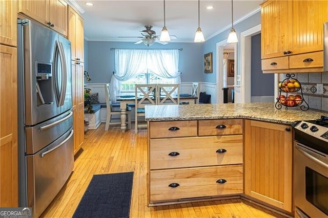 2050 Lyda Ln, Loganville, GA 30052 - kitchen with stainless steel appliances, ornamental molding, a peninsula, ceiling fan, and light wood finished floors