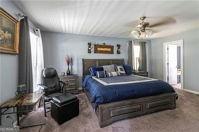 2050 Lyda Ln, Loganville, GA 30052 - carpeted bedroom with multiple windows, ensuite bath, ceiling fan, and baseboards