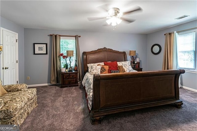 2050 Lyda Ln, Loganville, GA 30052 - bedroom with dark colored carpet, multiple windows, ceiling fan, and baseboards
