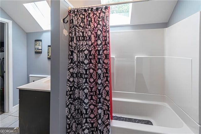 2050 Lyda Ln, Loganville, GA 30052 - bathroom with a skylight, vaulted ceiling, vanity, tile patterned flooring, and shower / bathtub combination with curtain