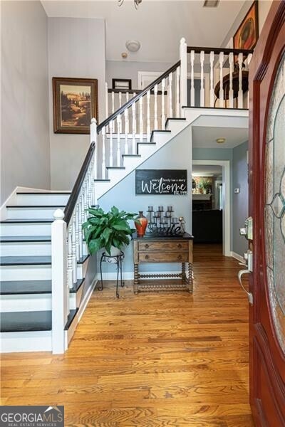 2050 Lyda Ln, Loganville, GA 30052 - foyer entrance with stairs, wood finished floors, and baseboards