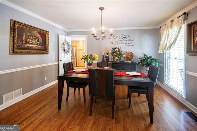 2050 Lyda Ln, Loganville, GA 30052 - dining space with a chandelier, wood finished floors, ornamental molding, and baseboards