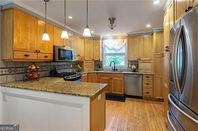 2050 Lyda Ln, Loganville, GA 30052 - kitchen with stainless steel appliances, a sink, a peninsula, light stone counters, and backsplash