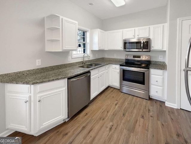 2555 Flat Shoals Rd Unit 3405, Atlanta, GA 30349 - kitchen featuring stainless steel appliances, white cabinets, wood finished floors, and dark stone counters