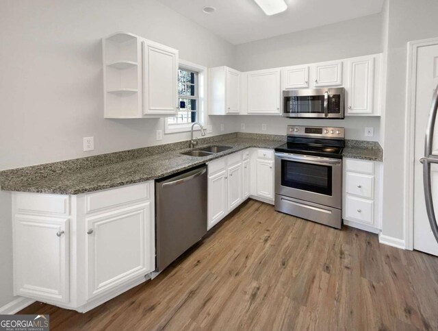 2555 Flat Shoals Rd Unit 3405, Atlanta, GA 30349 - kitchen featuring stainless steel appliances, white cabinets, wood finished floors, and dark stone counters