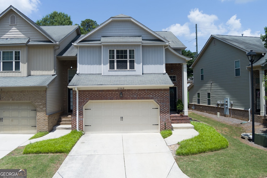 2968 Oshields Ct SW, Marietta, GA 30060 - view of property with a garage, board and batten siding, brick siding, and driveway