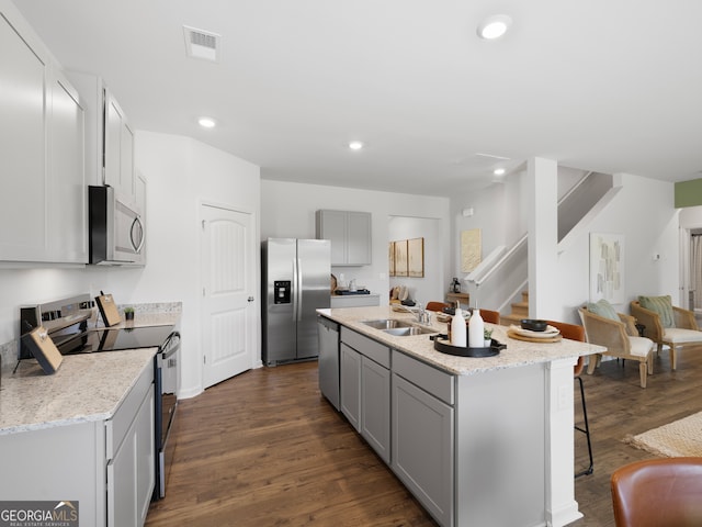 8215 Coldstream Dr, Fairburn, GA 30213 - kitchen featuring appliances with stainless steel finishes, gray cabinetry, a breakfast bar, a kitchen island with sink, and recessed lighting