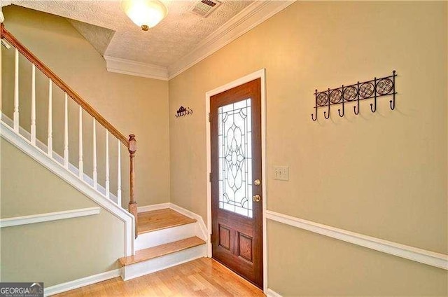 2212 Mcquiston Dr SW, Marietta, GA 30064 - entrance foyer featuring stairway, wood finished floors, ornamental molding, a textured ceiling, and baseboards