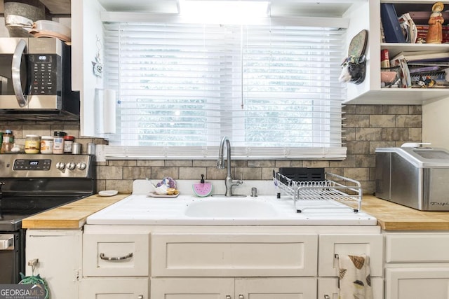 4009 Gray Hwy, Gray, GA 31032 - kitchen with appliances with stainless steel finishes, butcher block countertops, healthy amount of natural light, and tasteful backsplash