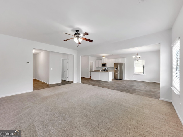 789 Galveston Way, Mcdonough, GA 30253 - unfurnished living room featuring a chandelier, baseboards, ceiling fan, and carpet floors