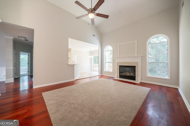 70 Sylvia Cir, Covington, GA 30016 - unfurnished living room with high vaulted ceiling, a ceiling fan, dark wood-style floors, baseboards, and a fireplace with flush hearth