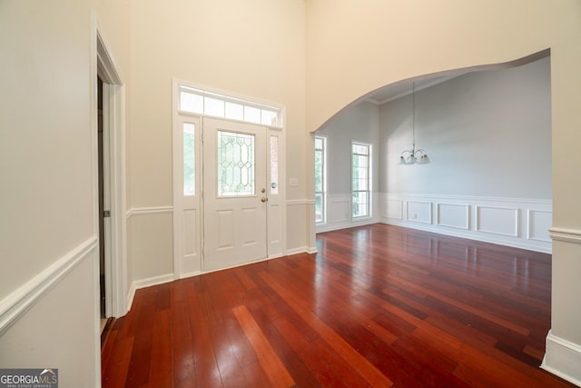 70 Sylvia Cir, Covington, GA 30016 - foyer featuring arched walkways, hardwood / wood-style floors, a chandelier, a high ceiling, and wainscoting