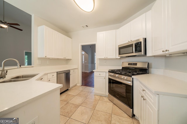70 Sylvia Cir, Covington, GA 30016 - kitchen with stainless steel appliances, a sink, a ceiling fan, light countertops, and white cabinetry