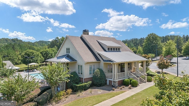 366 Lost Creek Blvd, Dallas, GA 30132 - view of front of property featuring a standing seam roof, covered porch, an outdoor pool, metal roof, and a wooded view