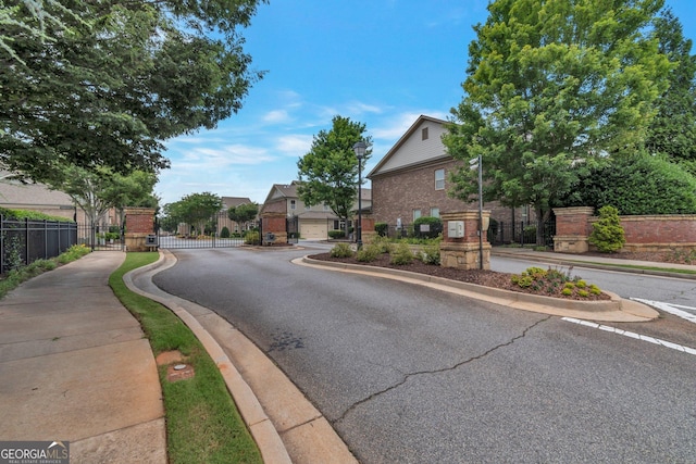 7850 Willoughby Ct, Alpharetta, GA 30005 - view of asphalt road featuring sidewalks, a gate, curbs, and a gated entry