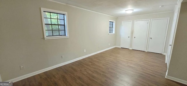 3226 Bruckner Blvd, Snellville, GA 30078 - unfurnished bedroom featuring ornamental molding, dark wood finished floors, baseboards, and multiple closets