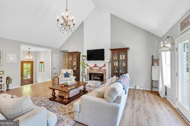 15 Split Oak Dr SW, Cartersville, GA 30120 - living room with a chandelier, high vaulted ceiling, light wood-style flooring, a fireplace, and plenty of natural light