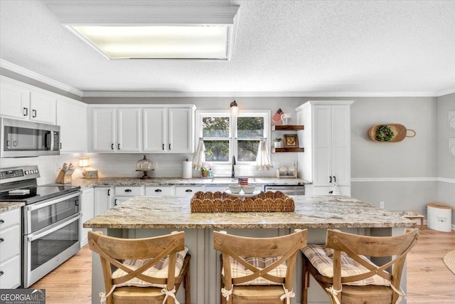 15 Split Oak Dr SW, Cartersville, GA 30120 - kitchen featuring appliances with stainless steel finishes, a kitchen breakfast bar, backsplash, white cabinets, and ornamental molding