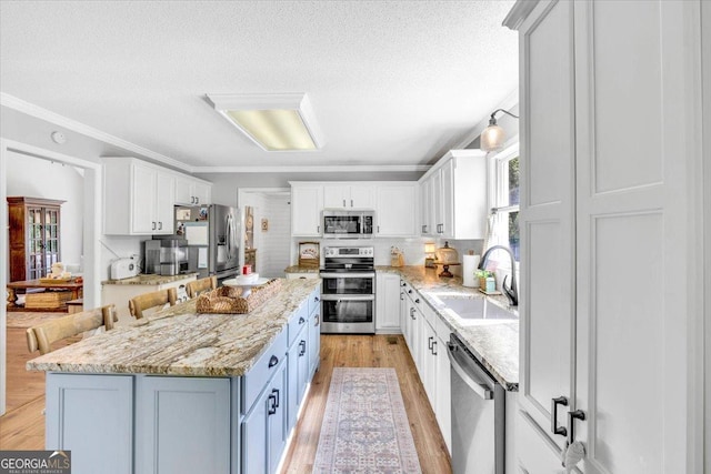 15 Split Oak Dr SW, Cartersville, GA 30120 - kitchen with appliances with stainless steel finishes, a sink, a textured ceiling, ornamental molding, and white cabinets