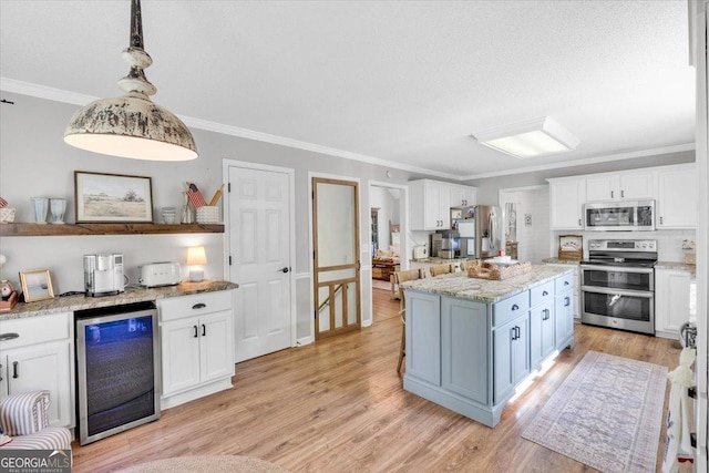 15 Split Oak Dr SW, Cartersville, GA 30120 - kitchen with appliances with stainless steel finishes, wine cooler, white cabinets, ornamental molding, and light stone counters