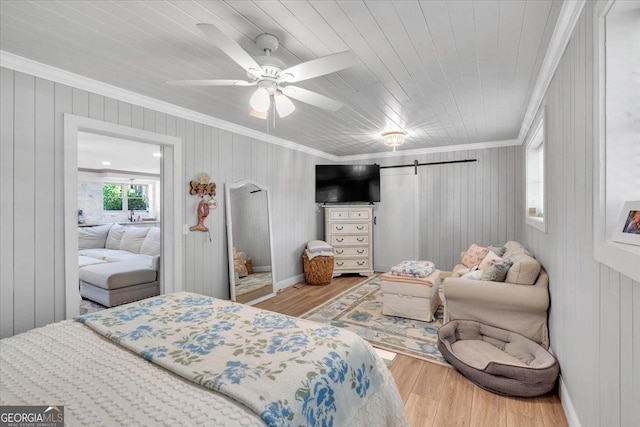 15 Split Oak Dr SW, Cartersville, GA 30120 - bedroom featuring wood finished floors, ornamental molding, a barn door, wooden walls, and a ceiling fan