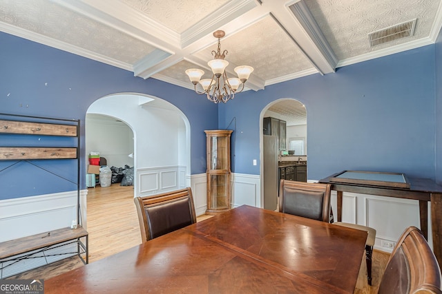 118 Surge Stone Ln, Stockbridge, GA 30281 - dining room with a chandelier, arched walkways, beamed ceiling, crown molding, and wood finished floors