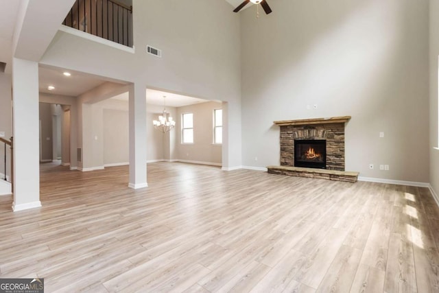 4000 Red Canoe Bnd, Lilburn, GA 30047 - unfurnished living room featuring a chandelier, light wood-type flooring, ceiling fan, a fireplace, and baseboards