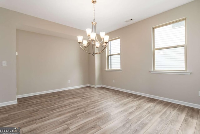 4000 Red Canoe Bnd, Lilburn, GA 30047 - spare room featuring light wood finished floors, a chandelier, and baseboards