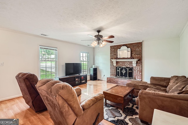 1739 Brandy Woods Trl SE, Conyers, GA 30013 - living area with light wood finished floors, ceiling fan, a fireplace, crown molding, and a textured ceiling